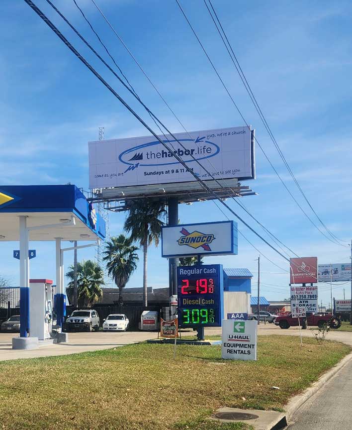 Roadside view of The Harbor's printed billboard in Friendswood